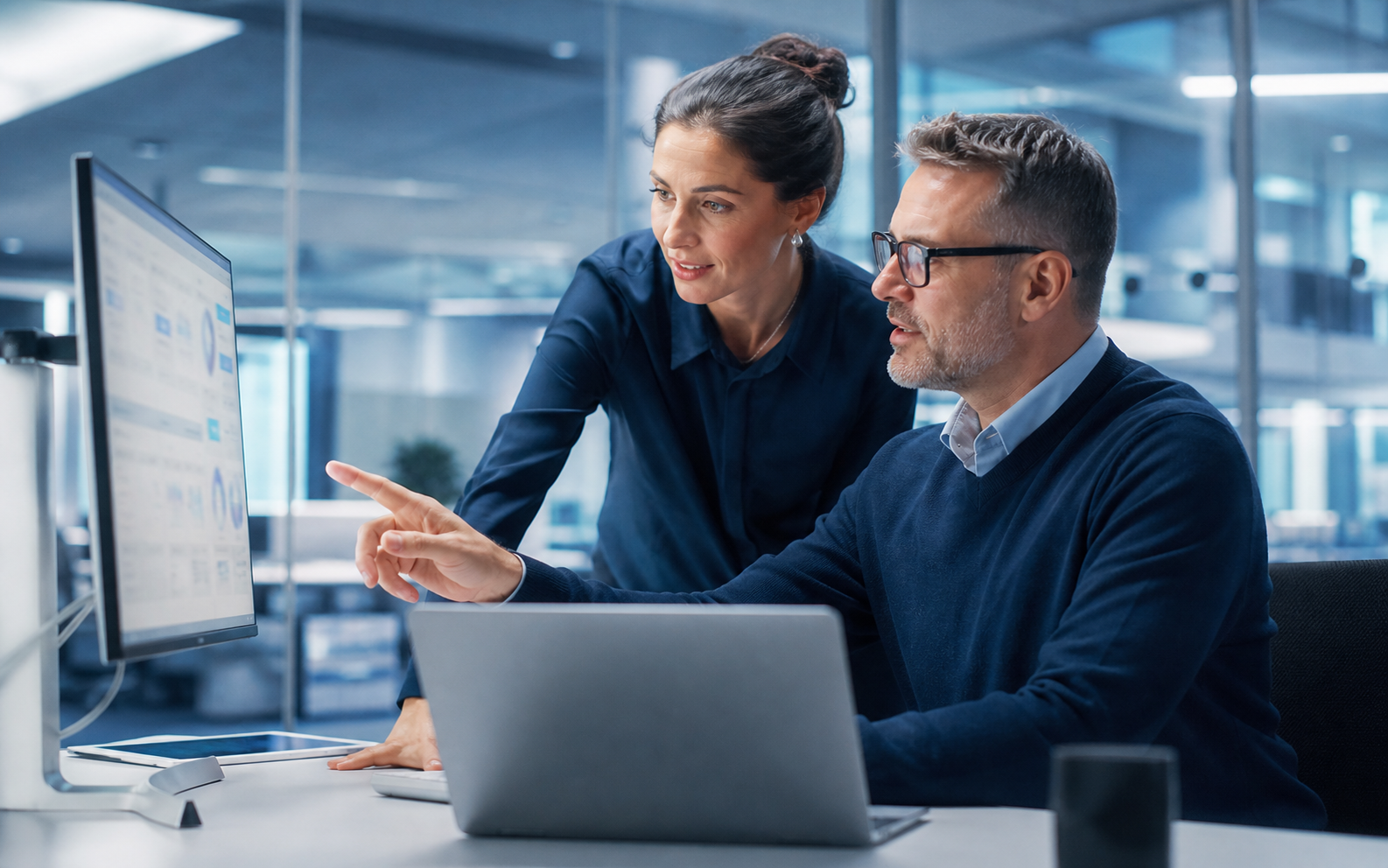IT coordinator reviewing Microsoft 365 identity access settings on a monitor in a small office